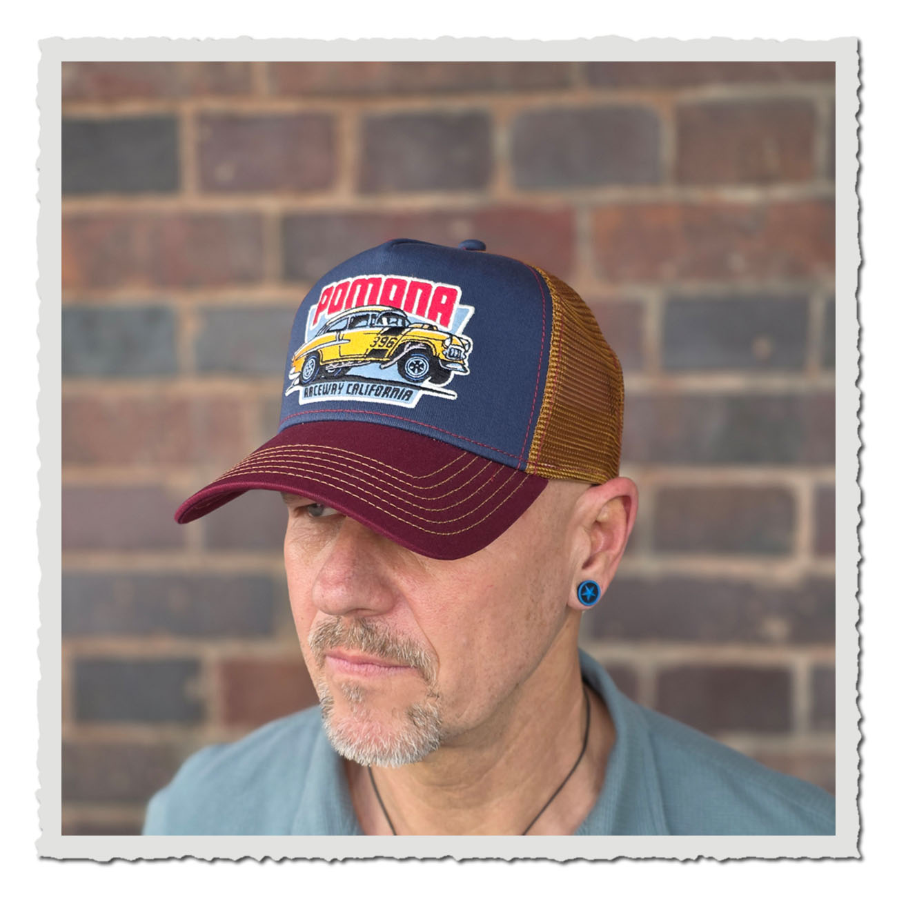 Mann trägt JJ Hats Trucker Cap im Racing-Look mit gelbem Hot-Rod Motiv und klassischem Mesh-Style