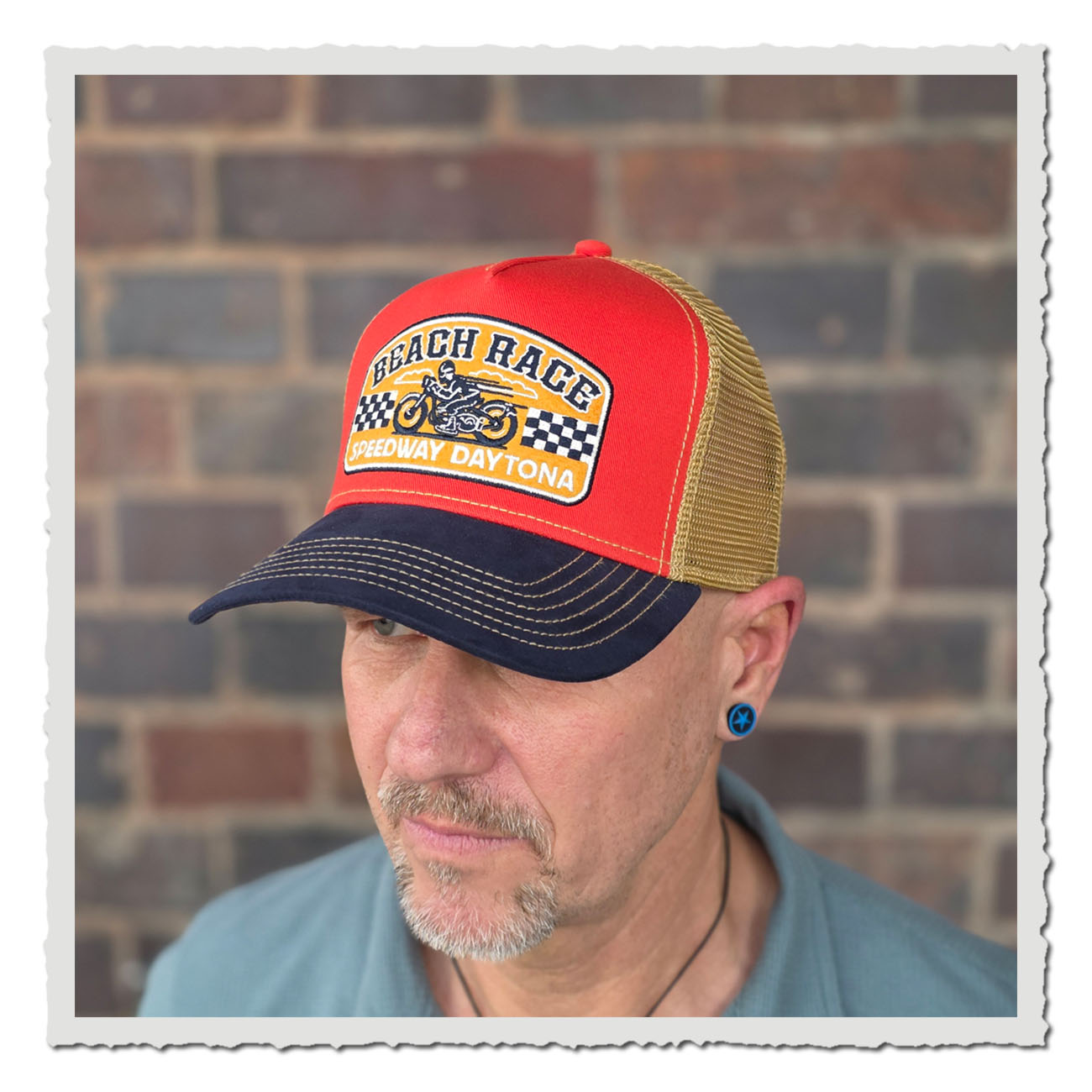 Mann trägt Vintage Meshcap JJ Hats Beach Race, Retro Trucker Cap in Orange mit gesticktem Speedway Daytona Patch