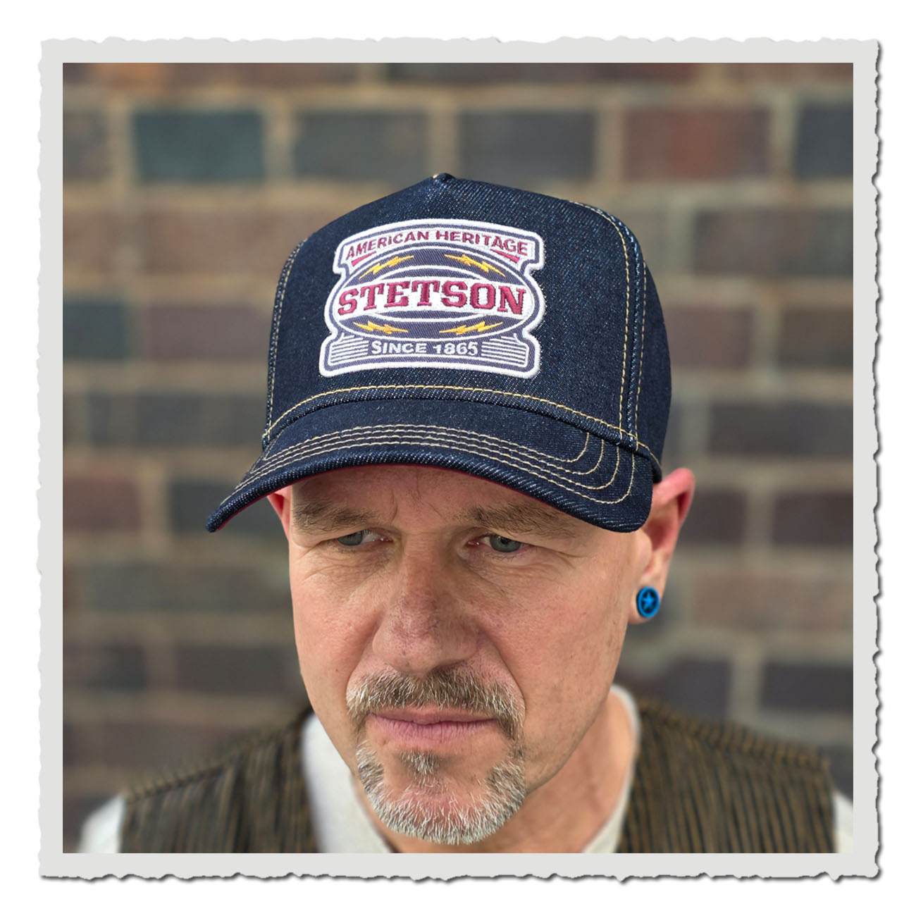 Mann trägt eine Stetson Trucker Cap Lightning im Denim-Look mit Heritage-Stickerei